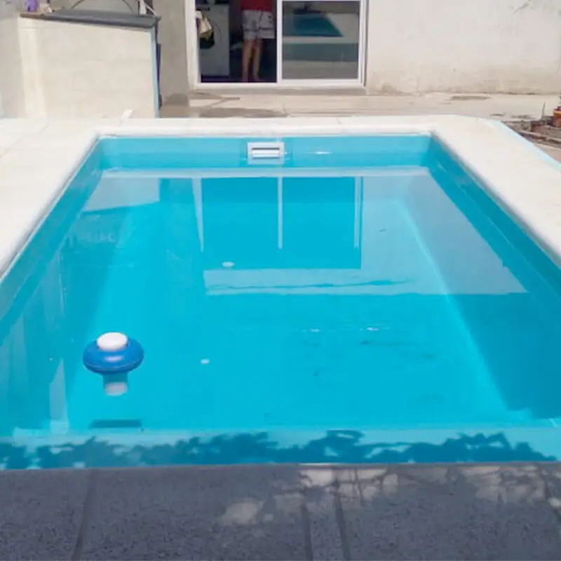 Piscina de fibra de vidrio instalada con terminación de borde por Los Aromos